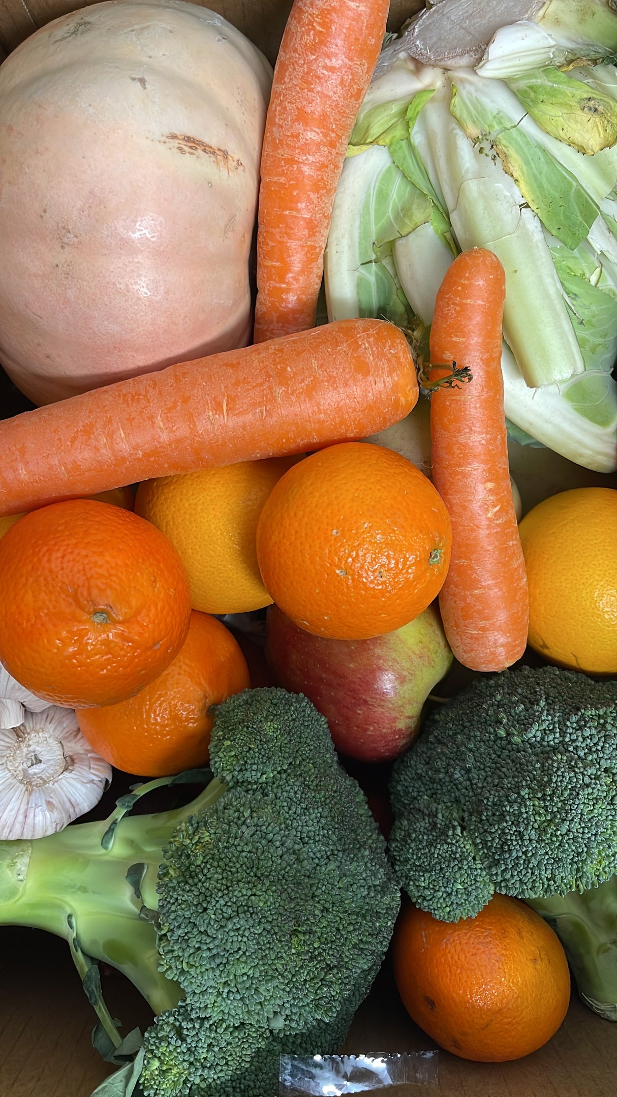 Assorted vegetables and fruits including carrots, broccoli, oranges, and apples.