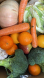 Assorted vegetables and fruits including carrots, broccoli, oranges, and apples.