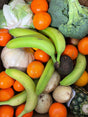 Assorted fruits and vegetables including bananas, oranges, and broccoli.